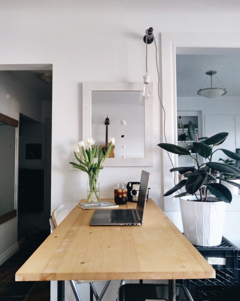 Home desk setup for growing an email list with Pinterest, laptop with iced coffee and fresh tulips