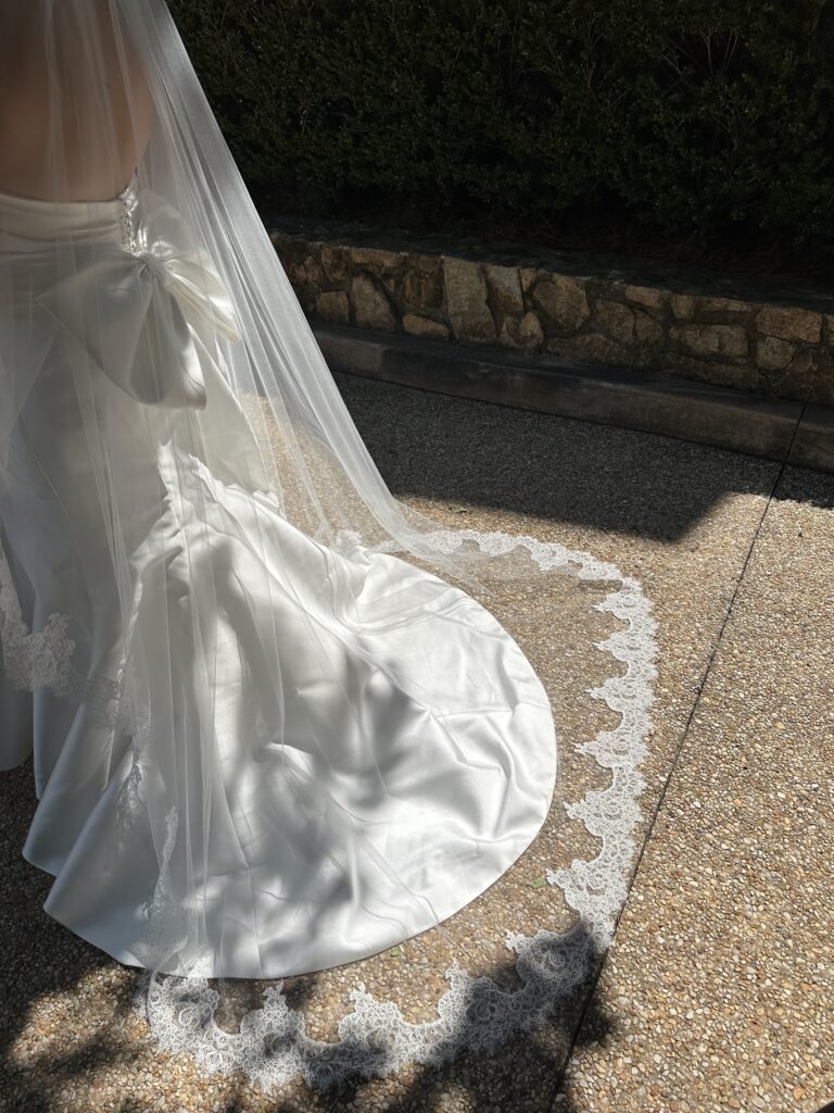 Close-up of a bridal gown train and lace-edged veil on a stone pathway — wedding photographer blog ideas for style and what-to-wear content targeting luxury and destination wedding clients